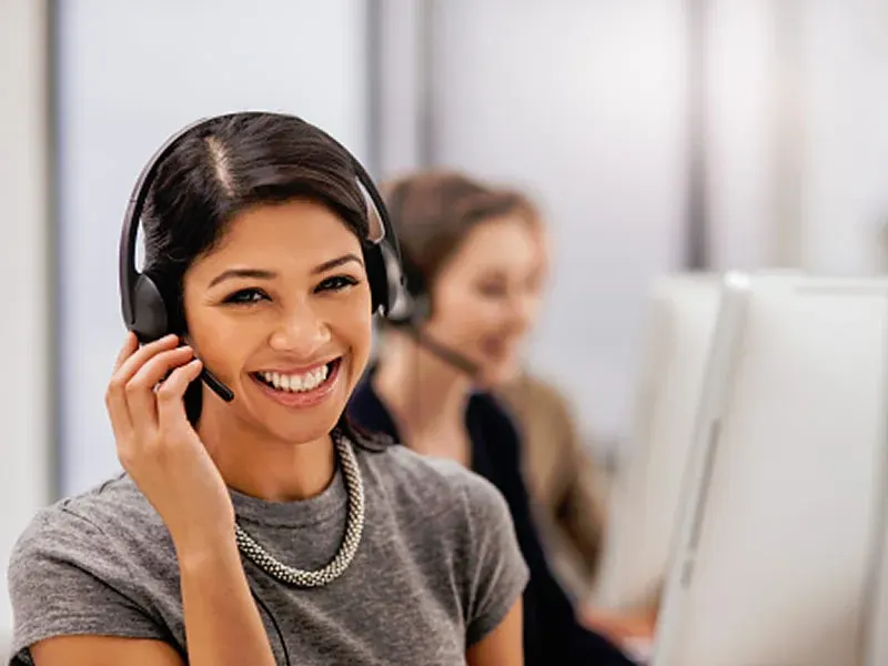 Customer service agent smiling while taking a call